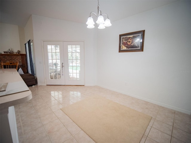 interior space with a brick fireplace, a chandelier, light tile patterned floors, and french doors