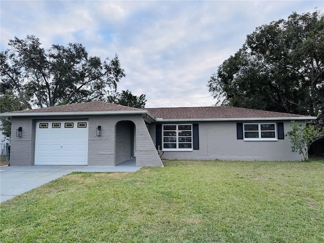 ranch-style house with a garage and a front lawn