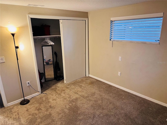 unfurnished bedroom featuring light carpet and a closet