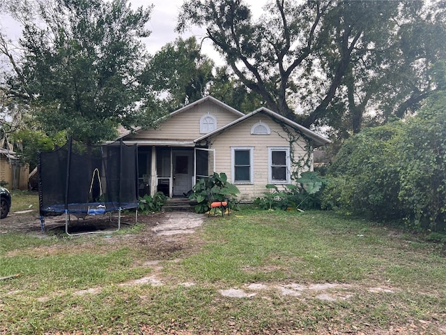 bungalow-style house featuring a front yard and a trampoline