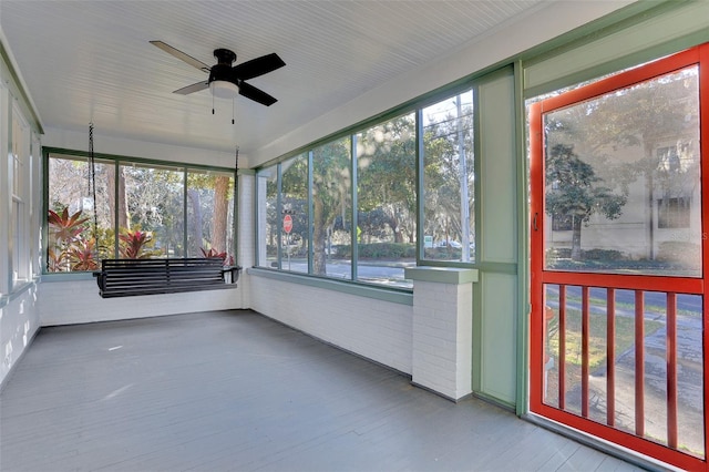 unfurnished sunroom with a wealth of natural light and ceiling fan