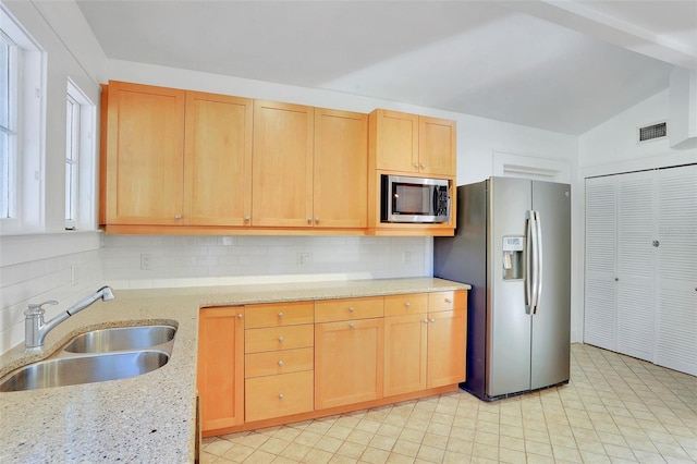 kitchen with sink, light brown cabinets, stainless steel appliances, backsplash, and vaulted ceiling