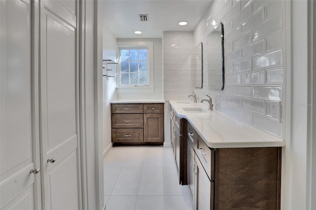 bathroom with tile patterned flooring, vanity, and tasteful backsplash