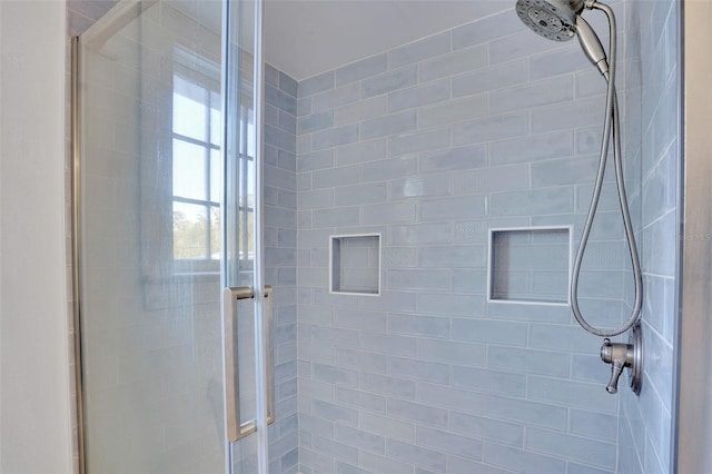 bathroom with a shower with door