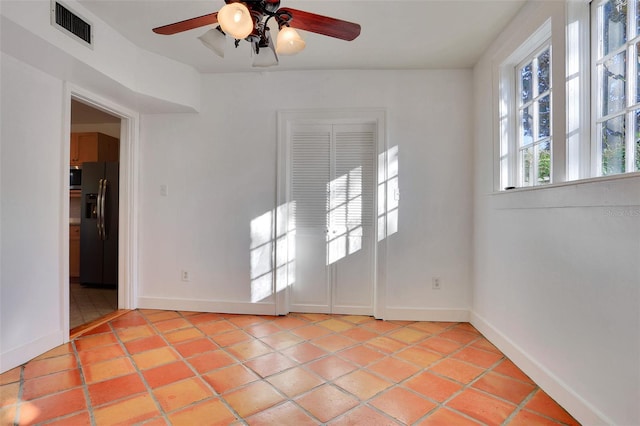 unfurnished room with ceiling fan and light tile patterned floors