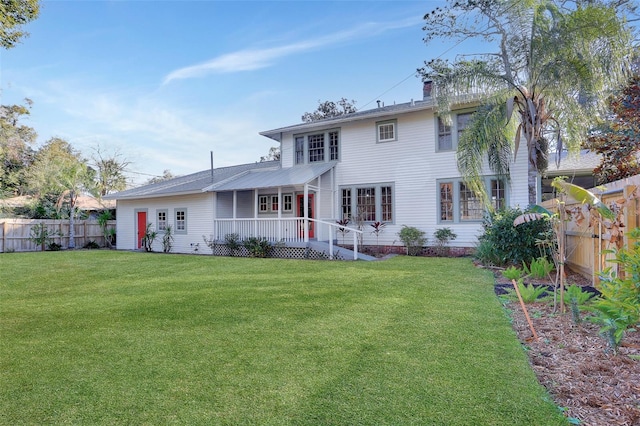 rear view of property with a yard