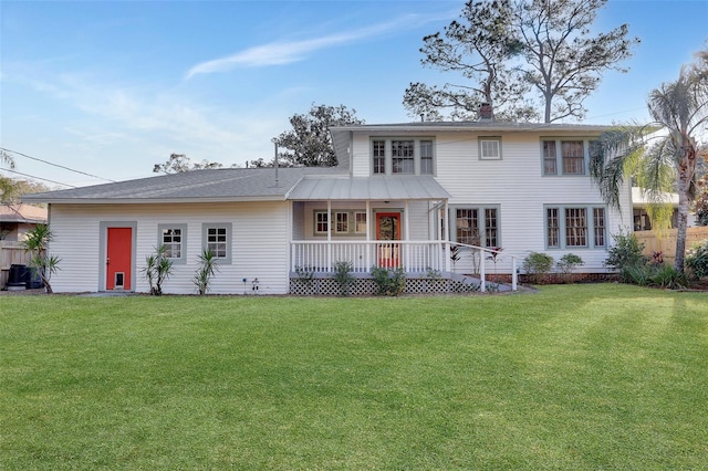 back of property with a lawn and a porch