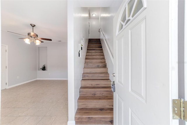 staircase with tile patterned floors and ceiling fan