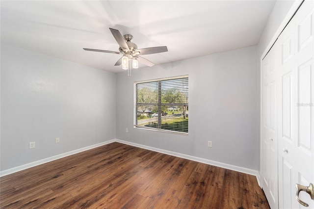 unfurnished bedroom featuring ceiling fan, a closet, and dark wood-type flooring