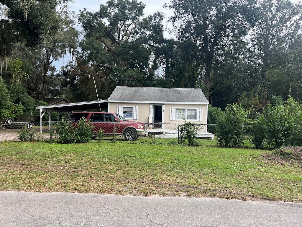 view of front of house with a front yard and a carport