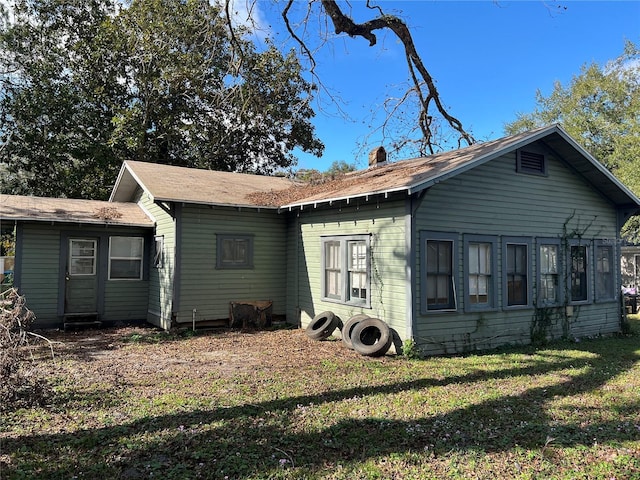 rear view of house featuring a yard