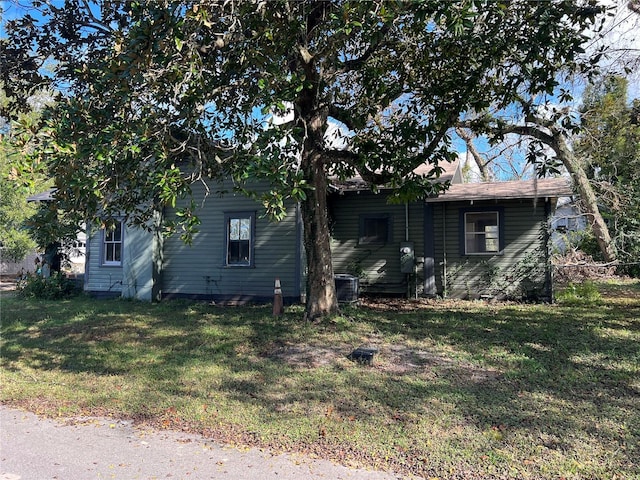 view of side of home with a yard and central air condition unit