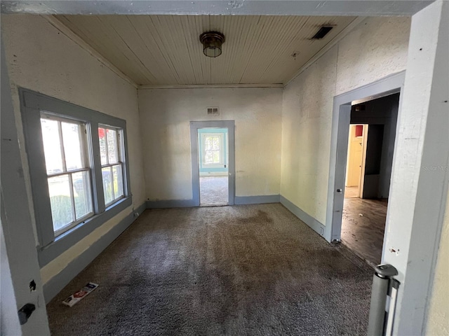 spare room featuring carpet and wood ceiling