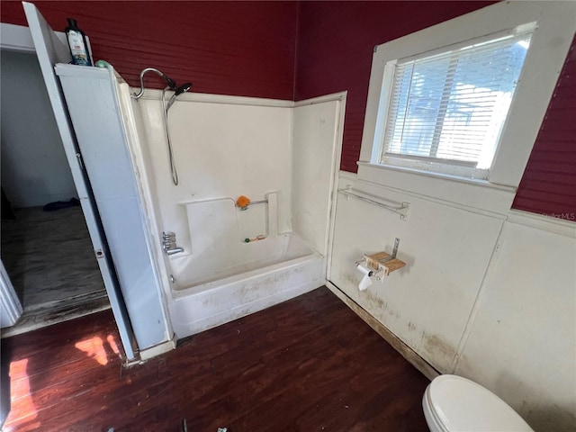 bathroom featuring toilet, wood-type flooring, and shower / washtub combination