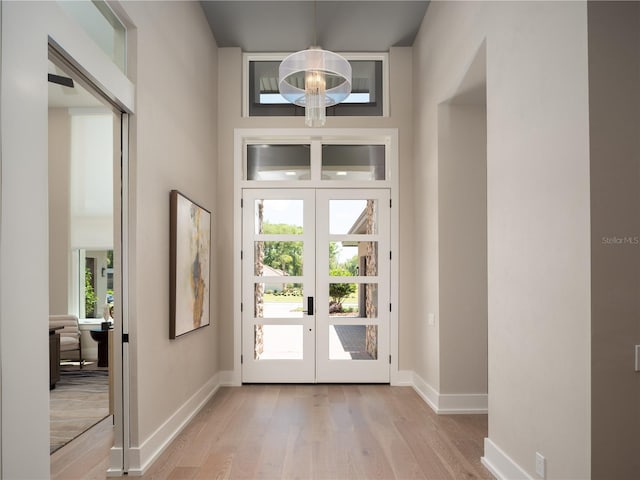 entryway with light hardwood / wood-style flooring, french doors, and a wealth of natural light