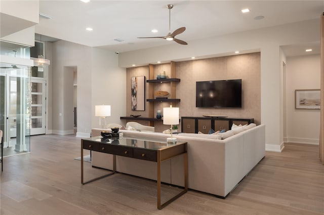 living room featuring light wood-type flooring and ceiling fan