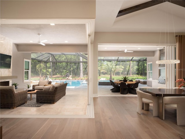 living room with light hardwood / wood-style floors, ceiling fan, a high end fireplace, and lofted ceiling