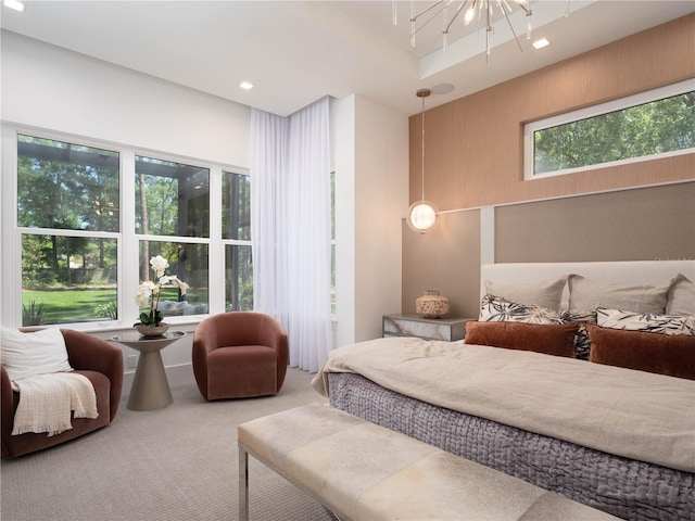 carpeted bedroom featuring multiple windows and a notable chandelier