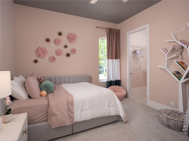 bedroom with a closet, light carpet, ceiling fan, radiator heating unit, and a walk in closet