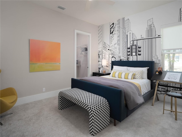 carpeted bedroom with a walk in closet, a closet, and ceiling fan