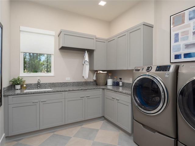 washroom featuring sink, cabinets, and independent washer and dryer