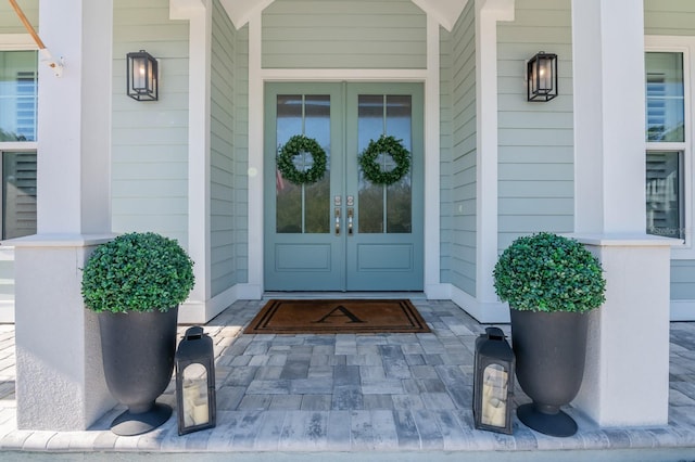 property entrance with covered porch and french doors