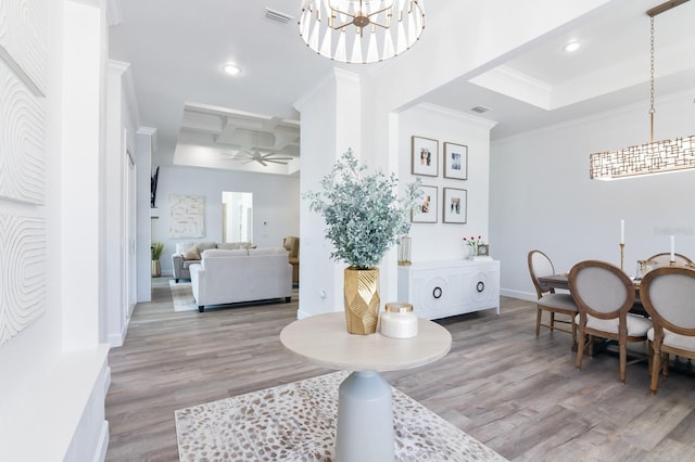 dining space featuring hardwood / wood-style floors, ceiling fan with notable chandelier, coffered ceiling, and ornamental molding