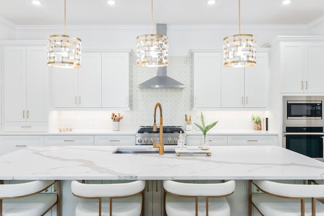 kitchen featuring a breakfast bar area, decorative backsplash, white cabinetry, and appliances with stainless steel finishes