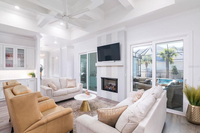 living room with beam ceiling, ceiling fan, light hardwood / wood-style floors, and coffered ceiling