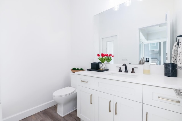 bathroom with toilet, vanity, and hardwood / wood-style flooring