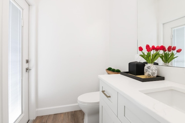 bathroom with hardwood / wood-style flooring, vanity, and toilet