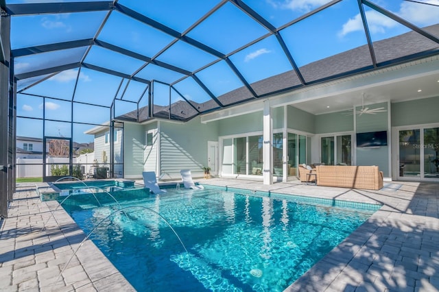 view of pool featuring glass enclosure, ceiling fan, pool water feature, and a patio