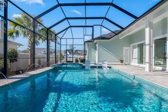 view of pool with an in ground hot tub, pool water feature, glass enclosure, and a patio area