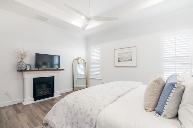 bedroom with ceiling fan, light wood-type flooring, and ornamental molding