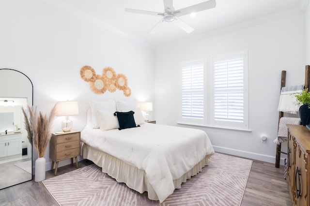 bedroom featuring light hardwood / wood-style floors, ensuite bath, ceiling fan, and ornamental molding