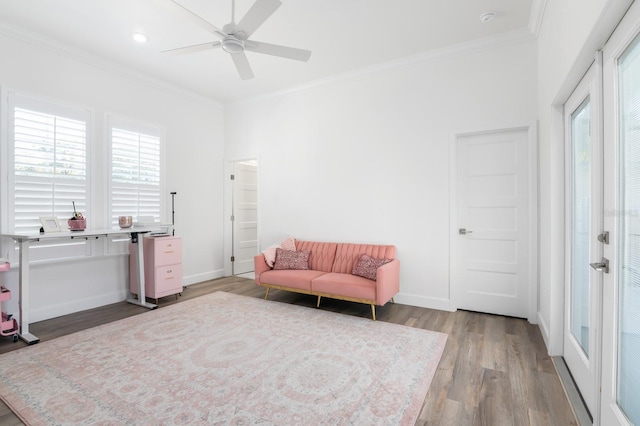 sitting room with ceiling fan, light wood-type flooring, and ornamental molding