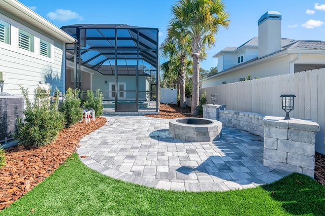 view of patio featuring cooling unit, an outdoor fire pit, and a lanai