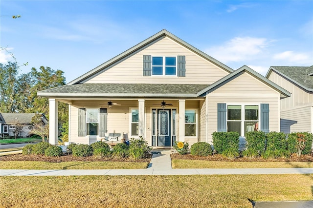 view of front of house with ceiling fan, covered porch, and a front lawn