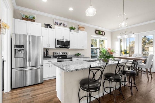 kitchen with sink, a center island with sink, white cabinets, and appliances with stainless steel finishes