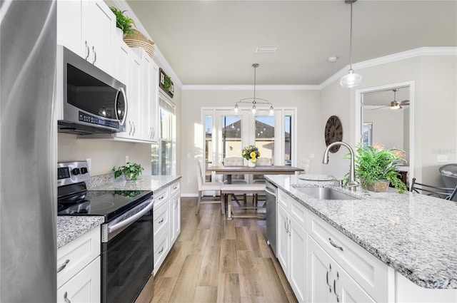 kitchen featuring white cabinetry, a kitchen island with sink, sink, and appliances with stainless steel finishes