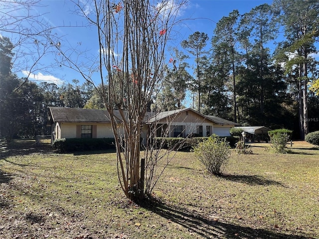 view of side of home featuring a yard and a carport