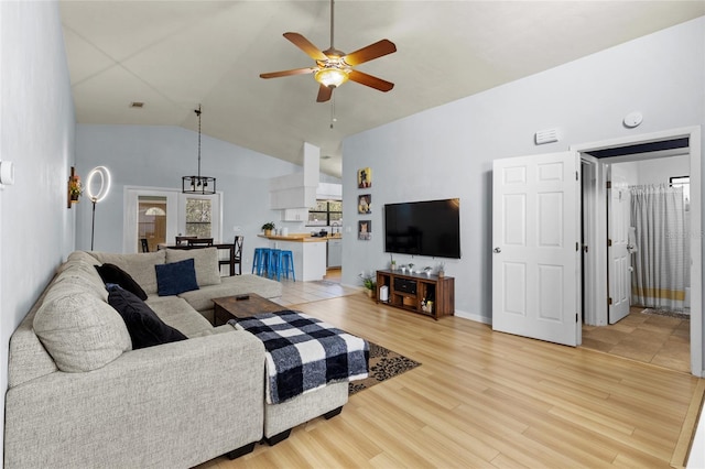 living room with ceiling fan, hardwood / wood-style floors, and high vaulted ceiling