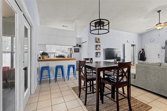 dining area with ceiling fan, light tile patterned floors, and lofted ceiling