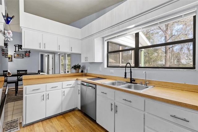 kitchen featuring sink, white cabinets, and dishwasher