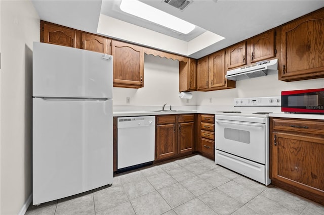 kitchen featuring a raised ceiling, sink, and white appliances