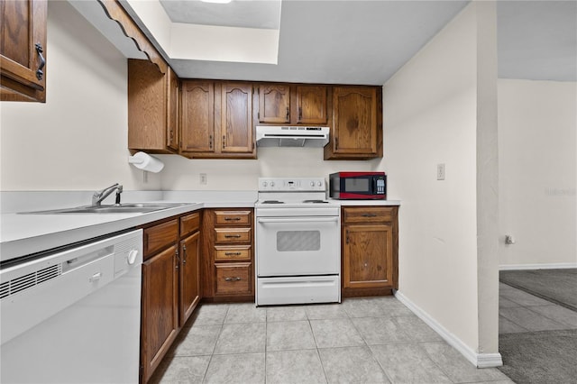 kitchen with sink, light tile patterned floors, and white appliances