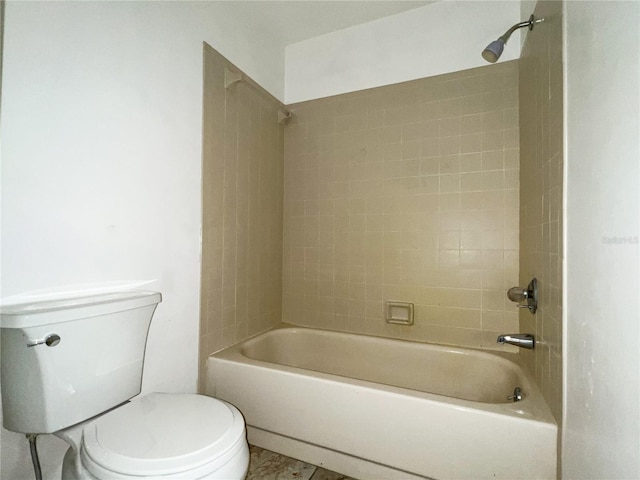 bathroom with tile patterned flooring, tiled shower / bath combo, and toilet