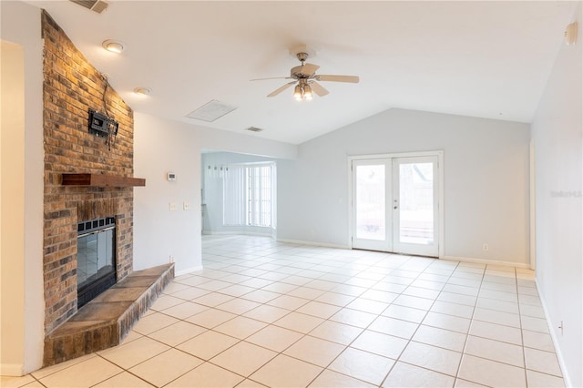 unfurnished living room featuring vaulted ceiling, light tile patterned floors, ceiling fan, a brick fireplace, and french doors