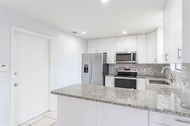 kitchen featuring white cabinetry, appliances with stainless steel finishes, kitchen peninsula, and sink