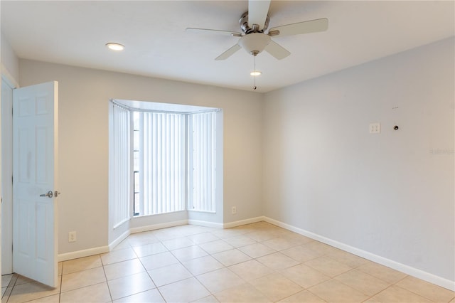 tiled empty room featuring ceiling fan